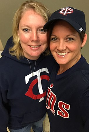 景观结构梅根（Megan）和艾莉森（Allison）在双胞胎棒球服装时为相机微笑。