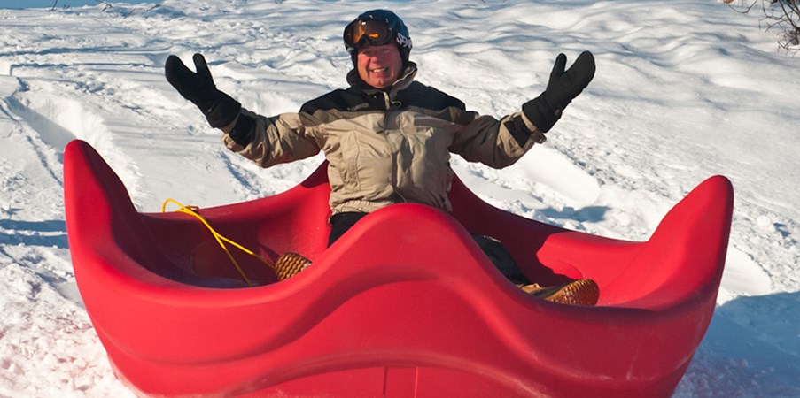景观结构的创始人史蒂夫·金（Steve King）在综合游乐场旋转器座椅上滑下一座白雪皑皑的山丘。