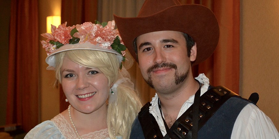 一个男人和女人在假日聚会上穿着西方服装微笑。