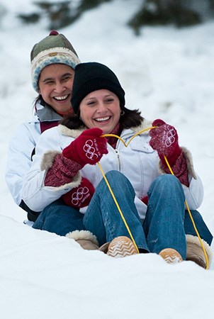 当他们溜走一座白雪皑皑的山丘时，两个人微笑。