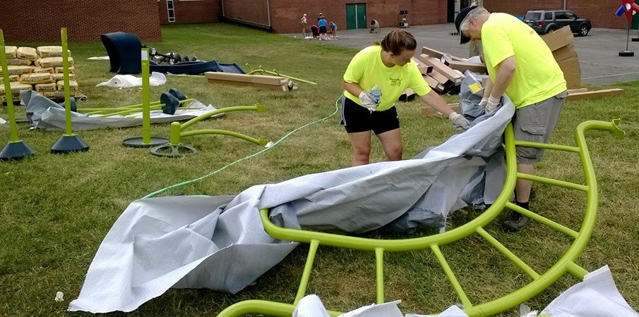 志愿者打开和布置游乐场建造的游乐场设备。