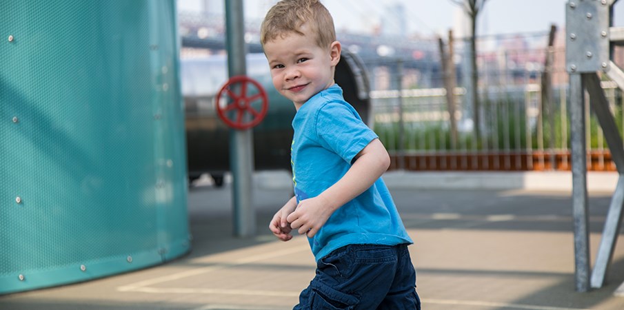 小男孩穿过多米诺公园的游乐场。