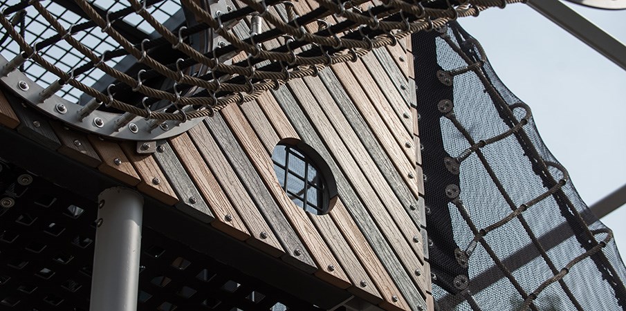 近距离观察一个圆形的窥视孔，通过一个游乐场塔的回收木板。